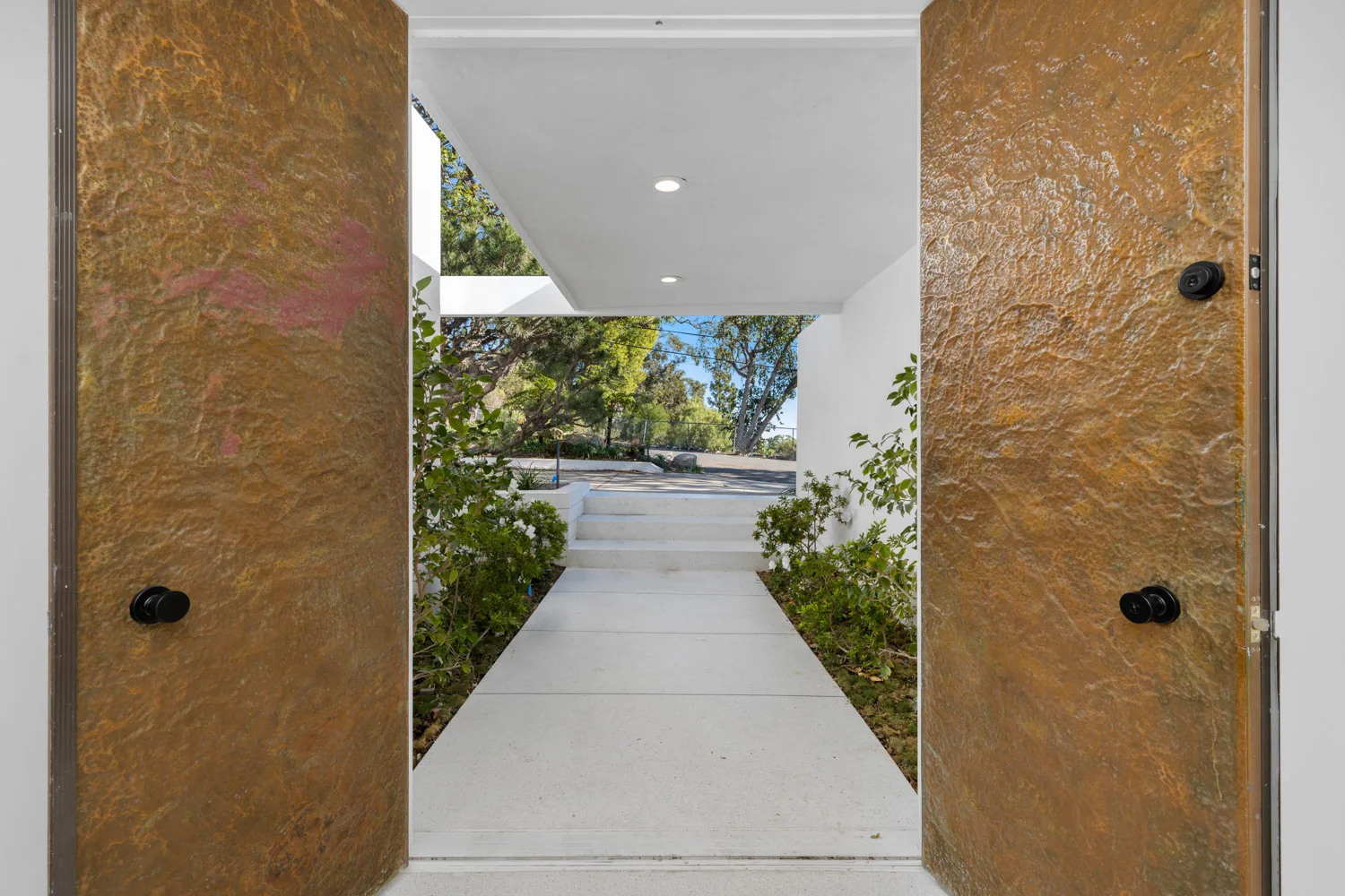 The bronze entry doors, open onto the court.