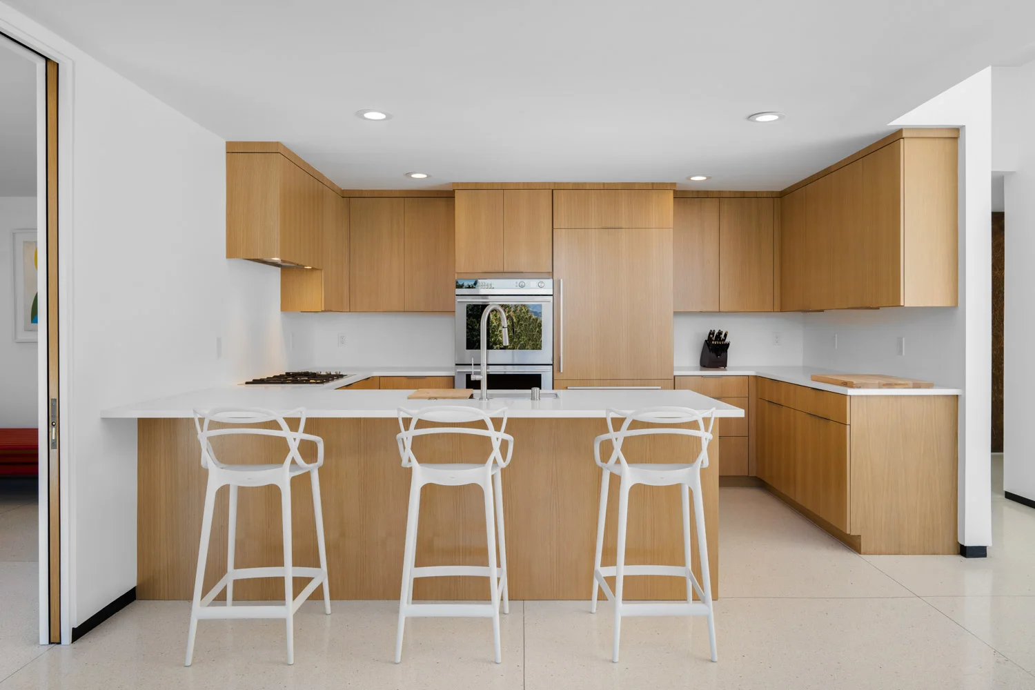 The kitchen: pale oak cabinetry and a white island.