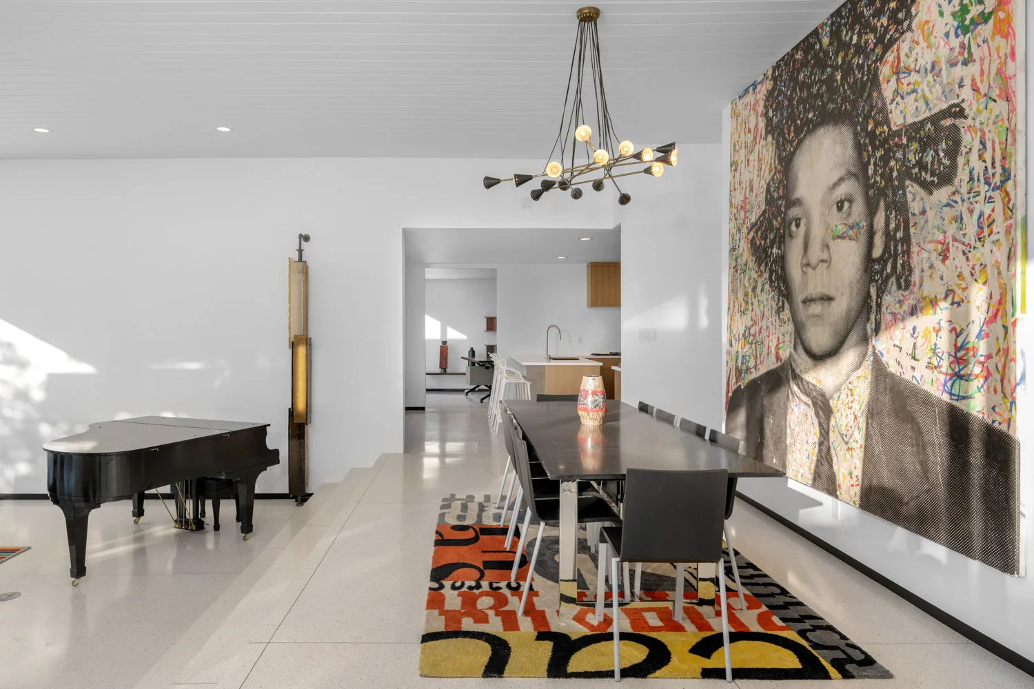 The dining room with a large portrait and a black chandelier.