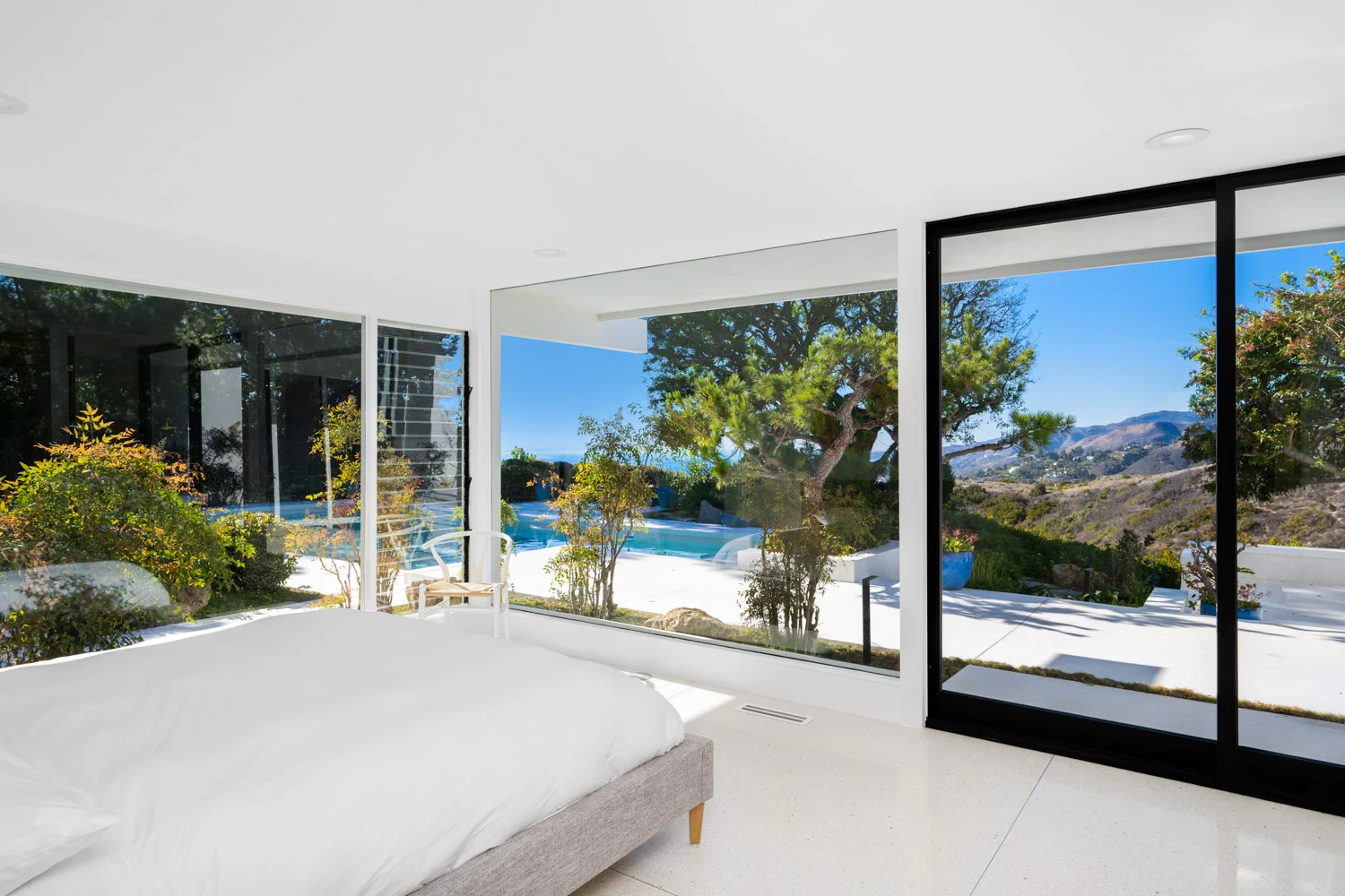 A bedroom opening onto the pool through sliding glass.