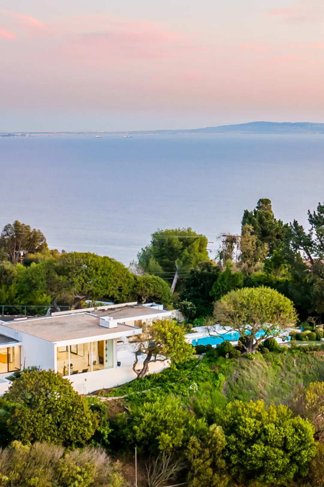 The Cool Oak House, Malibu, its walls of glass glowing at nightfall.