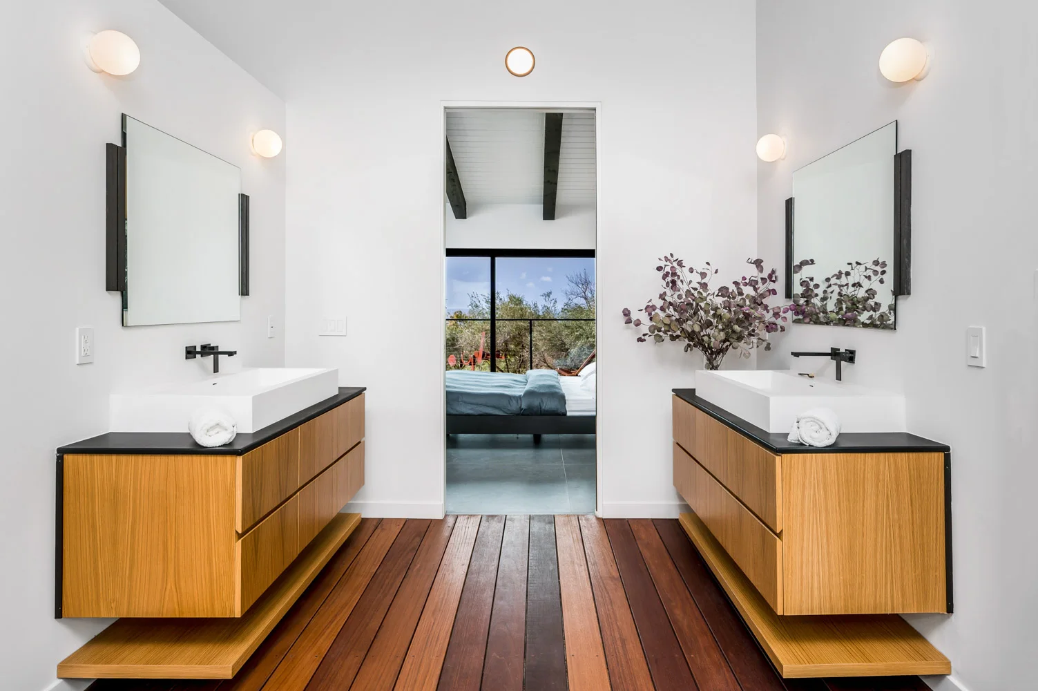 The main bathroom: twin basins on oak, the bedroom beyond.