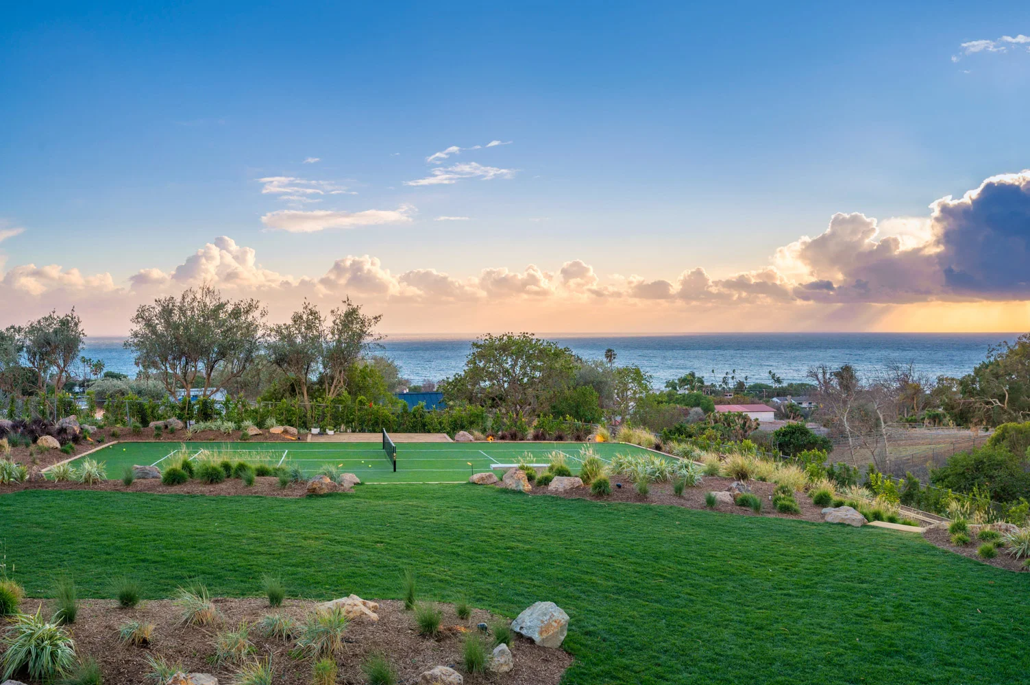 The garden at dusk, the lawn falling toward the ocean.