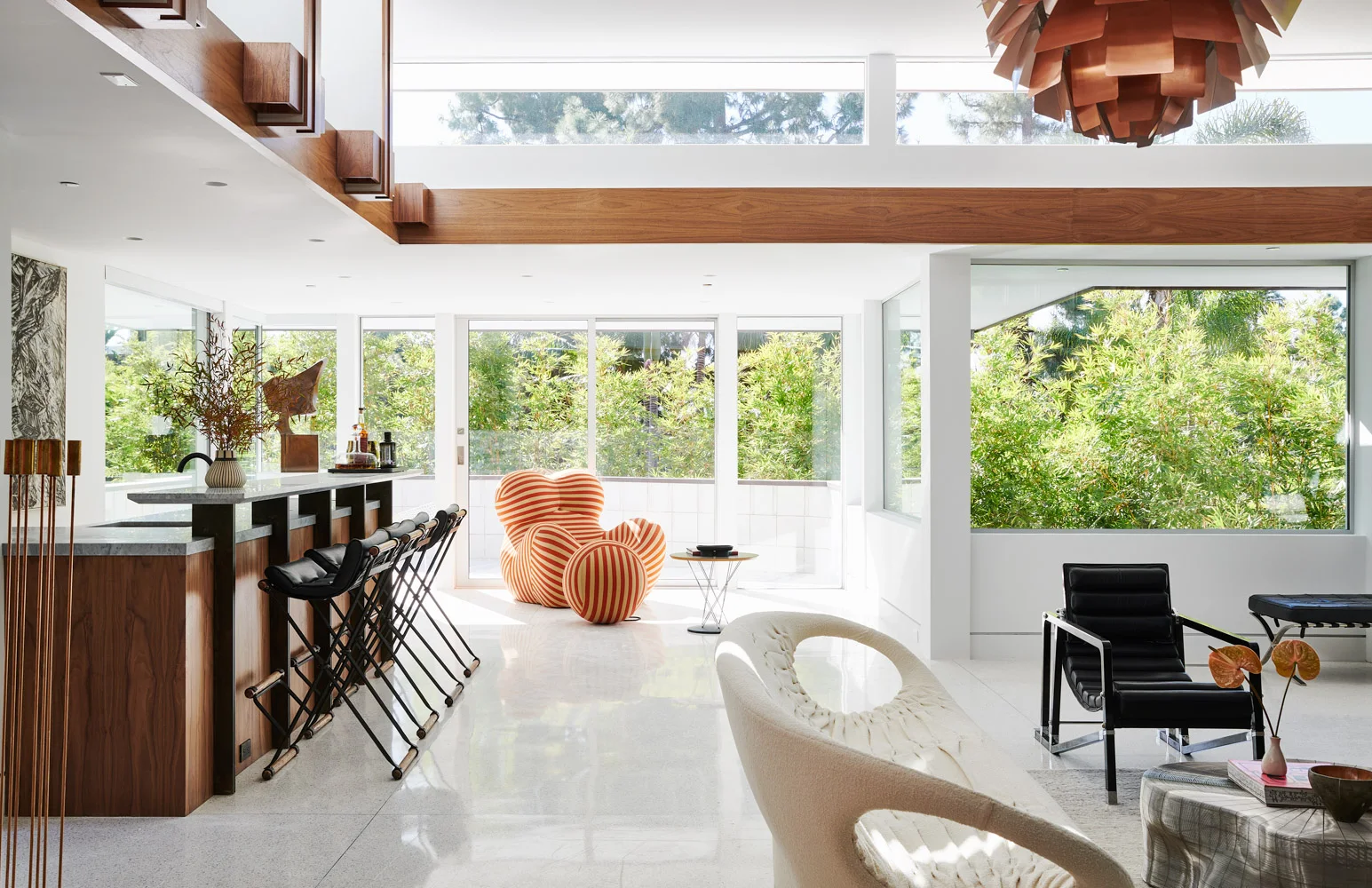 The living room: walnut ceiling, white walls, a bar along the glass.
