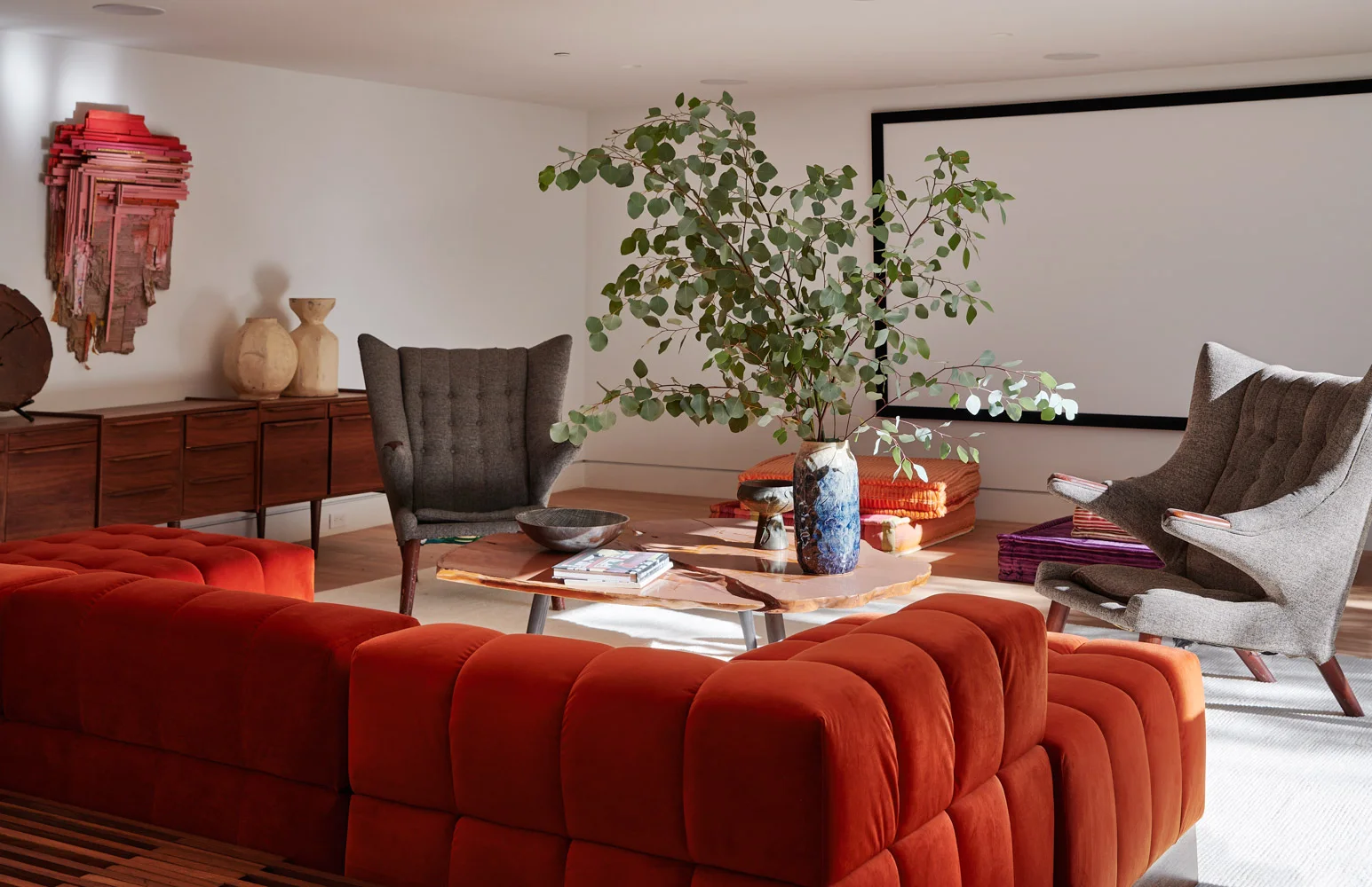 The media room: an orange sofa and a wingback chair.