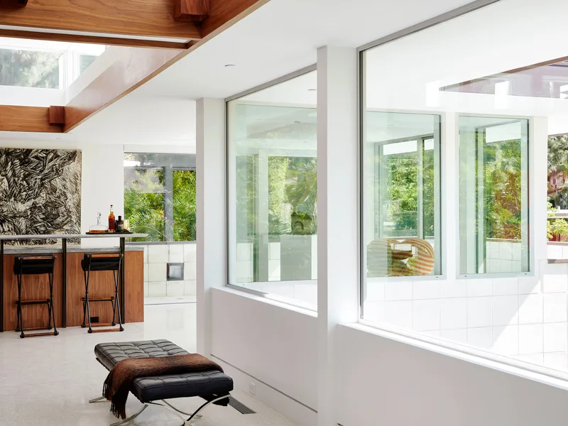 The bar at 1061 Loma Vista: walnut, glass and a leather chaise.